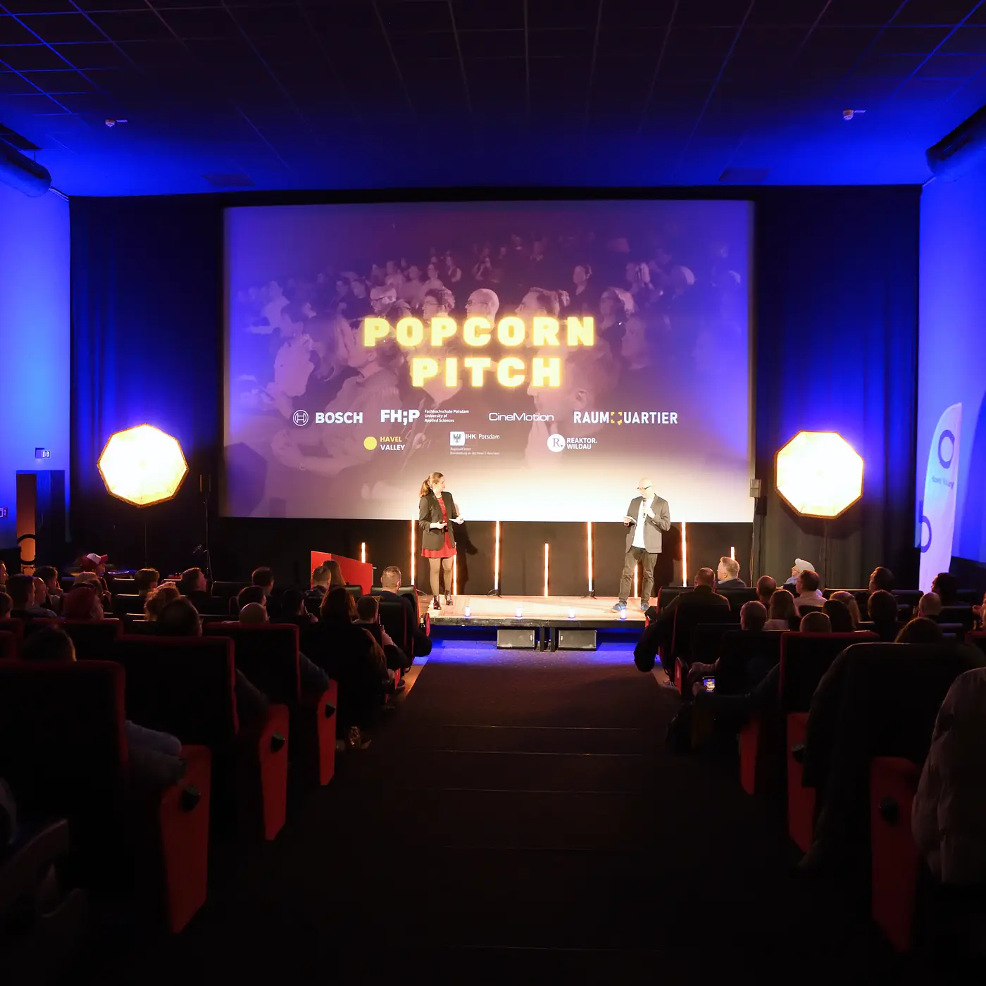 Voll besetzter Kinosaal im CineMotion Brandenburg beim Popcorn Pitch 2025, auf der Leinwand der Schriftzug Popcorn Pitch